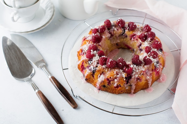 Zitronen-Bundt-Kuchen mit Himbeeren auf einem Licht.