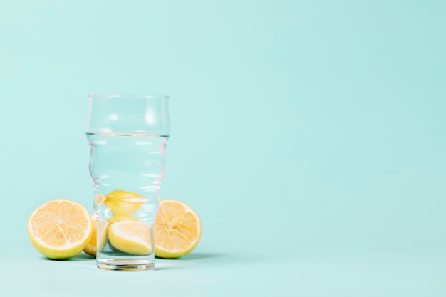 Zitronen und Glas auf blauem Hintergrund
