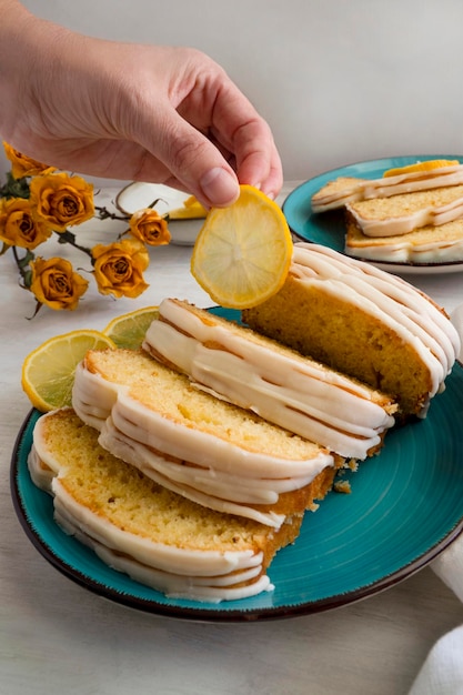 Zitronenkuchen. Handgehaltene Zitronenscheibe. Einfaches hausgemachtes Dessert zum Frühstück.