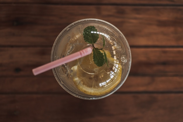 Zitronenlimonade in Plastikglas auf Holztisch im Café