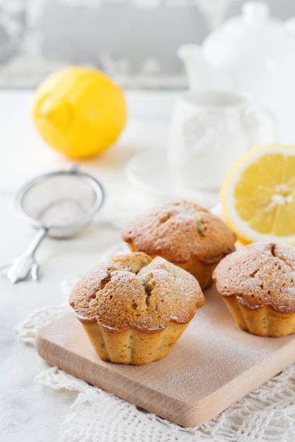 Zitronenmuffins mit Mohn auf einem Holzständer auf einem Leuchttisch. Selektiver Fokus.