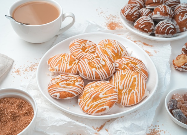 Zitronenplätzchen und kleine Eclair-Kuchen auf einem weißen Hintergrund. Draufsicht, horizontal.