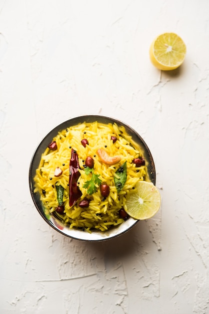 Zitronenreis oder Fodnicha Bhat ist ein südindisches Kurkuma-Reis- oder Maharashtrian-Rezept mit Reisresten, garniert mit Nüssen-Curry-Blättern und Zitronensaft, selektiver Fokus