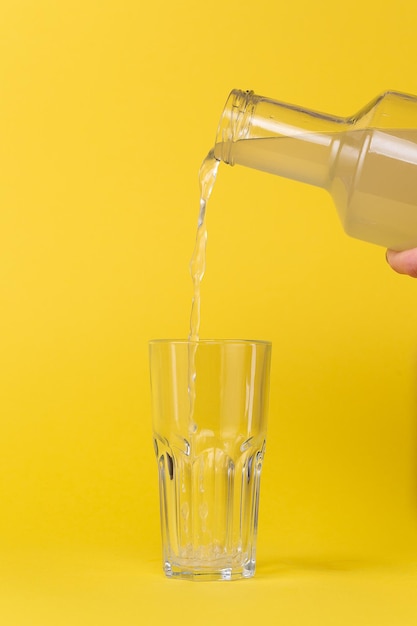 Zitronensaft wird mit einer Glasflasche in ein Glas gegossen