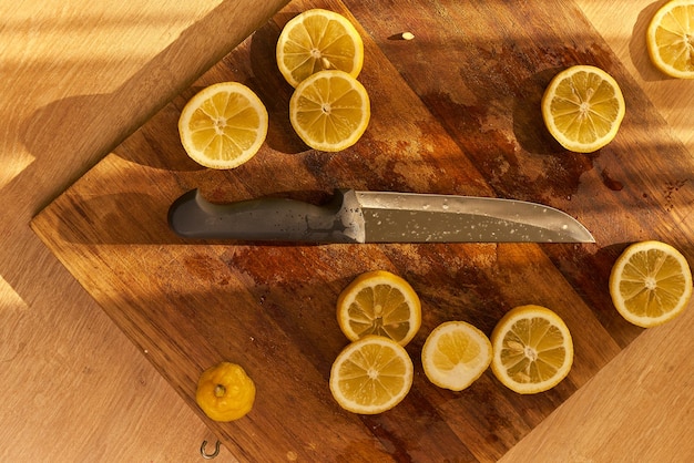 Zitronenscheiben und ein Obstmesser auf einem Holzschneidebrett