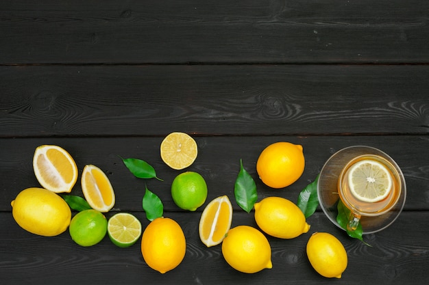 Zitronentee mit Zitrone und Kalk auf Holztisch