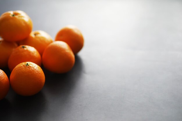 Zitrusfrüchte auf grauem Hintergrund. Mandarinen mit Blättern. Weihnachtsfrucht.