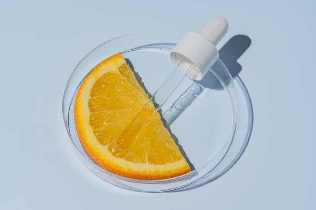 Foto zitruslaborforschung kosmetikproduktionen aha-komponenten extraktion hautpflege kosmetik prüfung petri-schüssel mit orangenfruchtscheibe und pipette