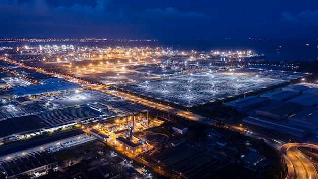 Zona de fábrica de vista aérea e porto de embarque no mar à noite