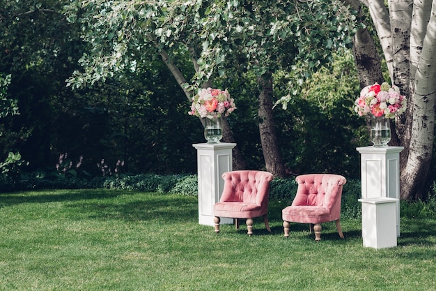 Zona de fotos com linda poltrona em um casamento decorado com flores e cubos de madeira