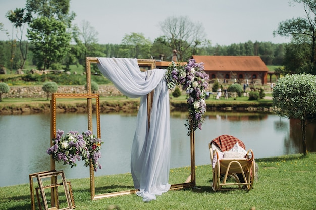 Zona de fotos en una boda cerca del lago con una silla. Decoración de boda de verano para invitados.