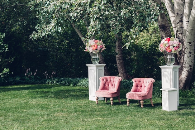 Zona de fotos con hermoso sillón en una boda decorada con flores y cubos de madera