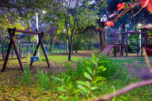 Zona de juegos entre árboles por la noche.