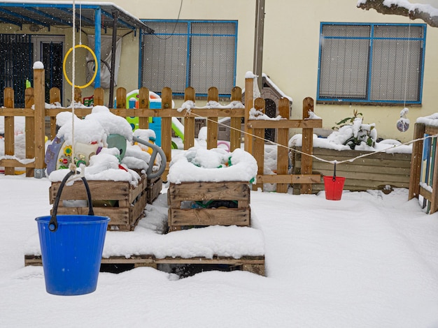 Zona de juegos vacía con juguetes en invierno con nieve, imagen de temporada de invierno