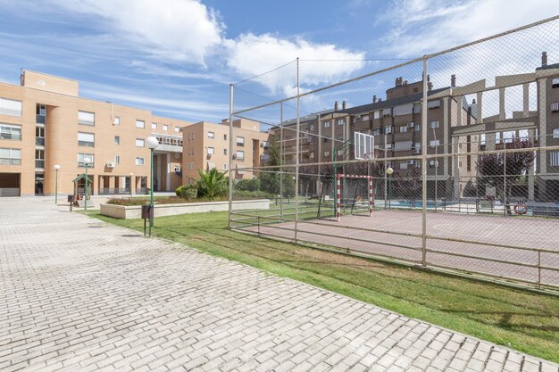 Zonas comunes con cancha de fútbol de 7 plazas ajardinadas y zonas de juegos infantiles en urbanización residencial