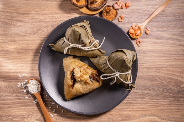 Zongzi, bolas de masa de arroz al vapor en la mesa de madera, hojas de bambú, comida en el concepto de duanwu del festival del barco del dragón, de cerca, espacio de copia, vista superior, endecha plana