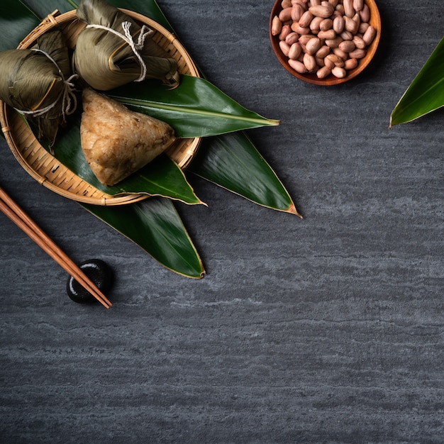 Zongzi. Concepto de diseño de vista superior de bola de masa de arroz para el tradicional Festival del Barco del Dragón (Festival Duanwu) sobre fondo de pizarra negra oscura.