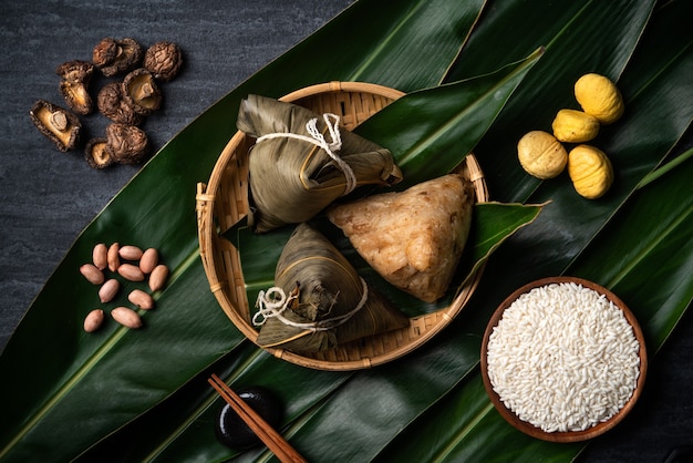 Zongzi. Concepto de diseño de vista superior de bola de masa de arroz para el tradicional Festival del Barco del Dragón (Festival Duanwu) sobre fondo de pizarra negra oscura.