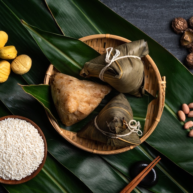 Zongzi. Concepto de diseño de vista superior de bola de masa de arroz para el tradicional Festival del Barco del Dragón (Festival Duanwu) sobre fondo de pizarra negra oscura.