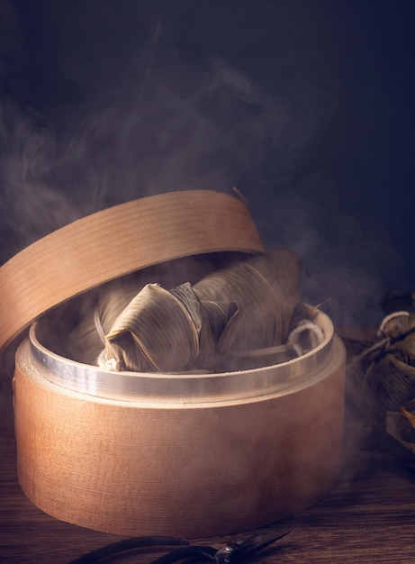 Zongzi gedämpfte Reisknödel im Dampfgarer auf Holztisch berühmtes leckeres Essen im Drachenbootfestival duanwu Designkonzept Nahaufnahme Kopierraum