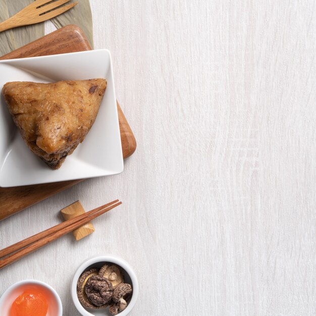 Zongzi. Köstliches traditionelles Reisknödelessen für Drachenboot-Duanwu-Festival über Draufsicht des hölzernen Tischhintergrundes.