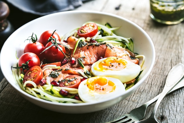 Zoodle de calabacín con salmón ahumado, huevo cocido y ensalada de granada con aderezo Pesto