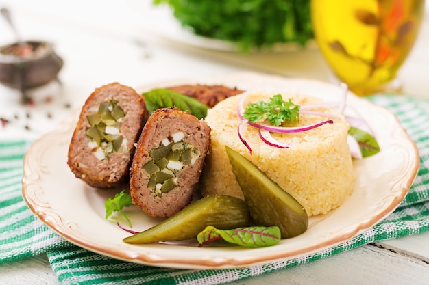 Zrazy Schnitzel mit Hackfleisch mit eingelegten Gurken und Eiern und Garnierung von Bulgur