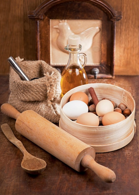 Zu Hause kochen Holzlöffel Spachtel Küchenutensilien auf einem Holztisch Einfache Produkte Mehl und Eier auf Holztisch