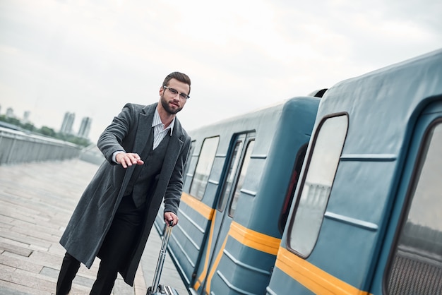 Zu spät für den Zug junger Geschäftsmann, der mit Gepäck in der Nähe der Eisenbahn läuft