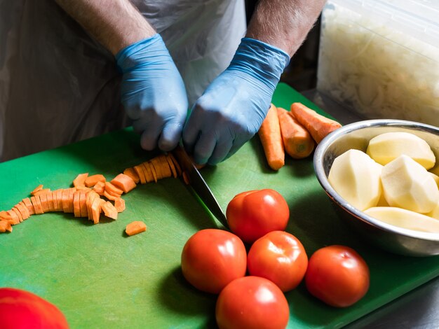 Zubereitung der Mahlzeiten. Koch, der Karotten schneidet. Rezept für ein gesundes Gemüsegericht