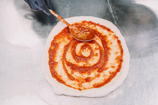 Foto zubereitung einer hausgemachten pizza nach italienischer art durch einen spezialisten