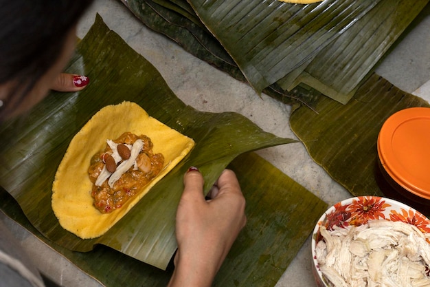 Foto zubereitung und zutaten einer in bananenblatt gewickelten hallaca oder tamale