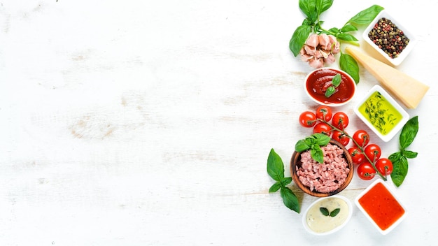 Zubereitung von Bolognese-Sauce auf einem weißen Hintergrund aus Holz Draufsicht Freier Platz für Ihren Text