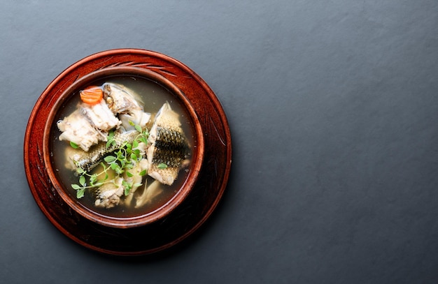 Zubereitung von Fischsuppe mit frischen Zutaten und aromatischen Gewürzen in einer Keramikschüssel