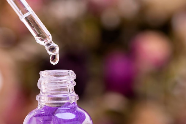 Zubereitung von Parfümen aus natürlichen Inhaltsstoffen Aromatherapie Glaspipette mit einem Tropfen Parfüm in Nahaufnahme