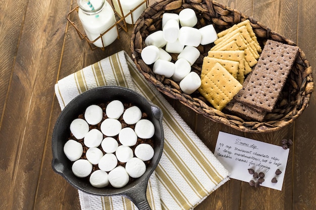 Zubereitung von Smores Dip mit großen Marshmallows in einer gusseisernen Pfanne zubereitet.