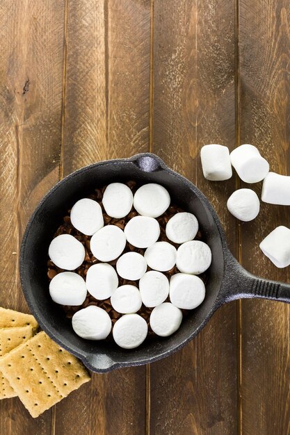 Zubereitung von Smores Dip mit großen Marshmallows in einer gusseisernen Pfanne zubereitet.