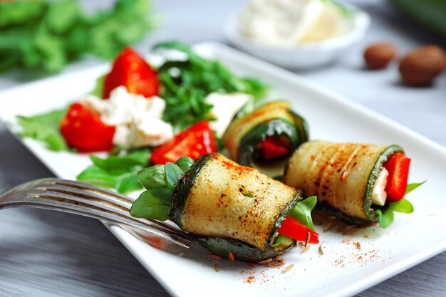 Zucchini-Brötchen mit Käsepaprika und Rucola auf Plattennahaufnahme