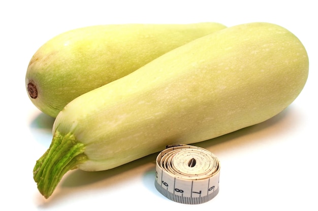 Zucchini gelb und Messband isoliert auf weißem Hintergrund