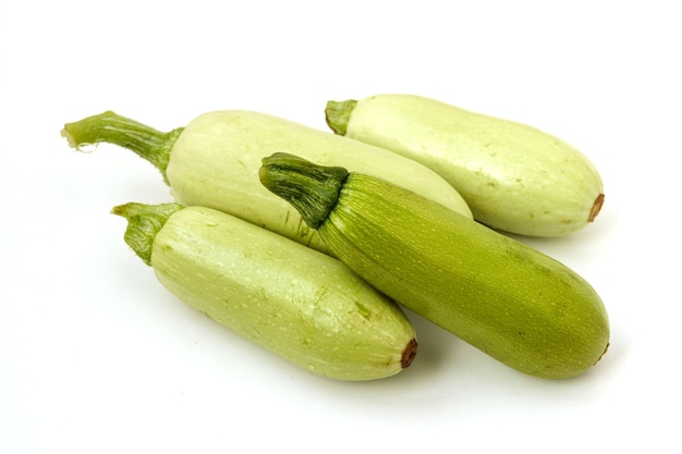 Zucchini in zufälliger Reihenfolge auf einer weißen Fläche angeordnet, Ansicht von oben
