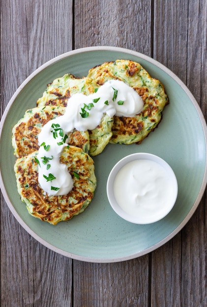 Zucchini-Krapfen oder Pfannkuchen mit Sauerrahm und Kräutern Gesunde Ernährung Vegetarisches Essen