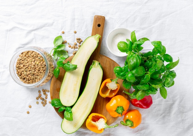 Zucchini, Paprika, Basilikum und Linsen auf weißem Hintergrund