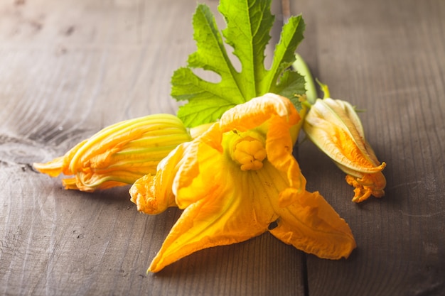 Zucchiniblüten auf einem Holztisch hautnah