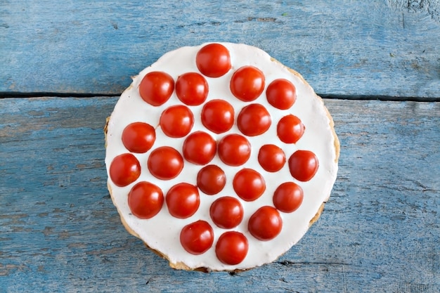 Zucchinikuchen mit Tomaten auf blauem Holzhintergrund