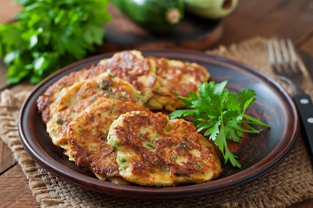 Zucchinipfannkuchen mit Petersilie auf einem Holztisch