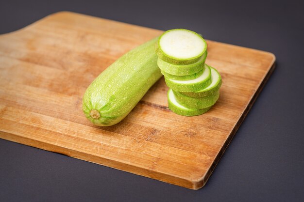 Zucchinischeiben auf Holzschneidebrett.