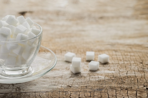 Zucker in der Tasse auf Holztisch