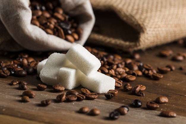 Foto zuckerblöcke und sack mit kaffeebohnen