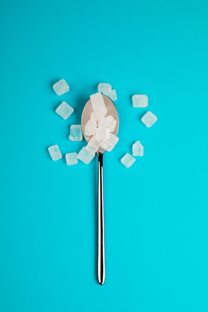 Zuckerersatzpillen in einem Löffel auf blauem Hintergrund