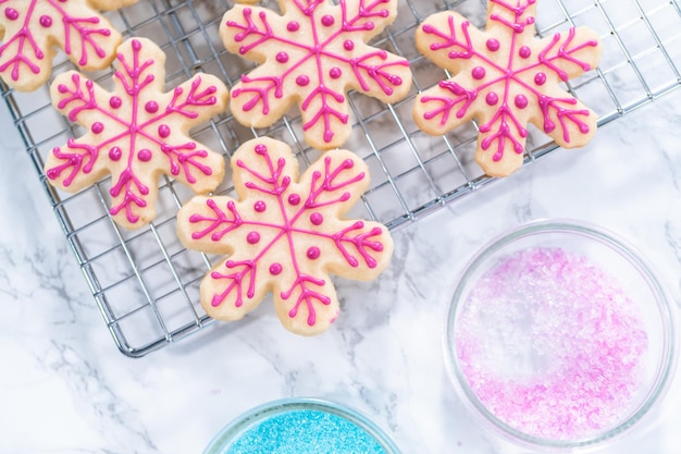 Zuckerkekse zu Weihnachten mit Zuckerguss und Streuseln dekorieren.